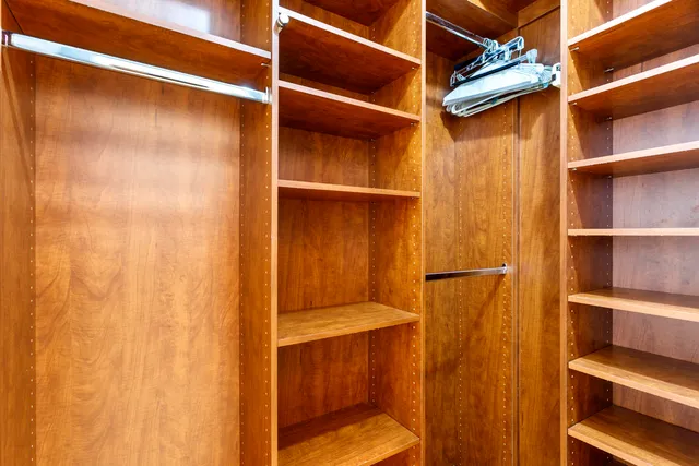 a view of walk in closet with empty racks