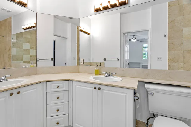 a bathroom with a granite countertop sink a toilet and a mirror