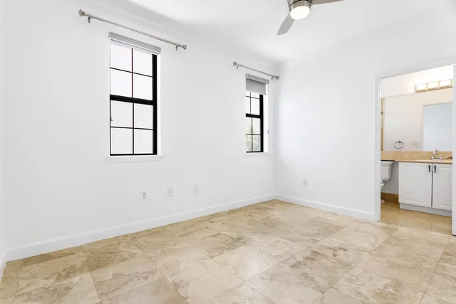 an empty room with windows and cabinet