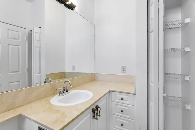 a bathroom with a granite countertop sink and a mirror
