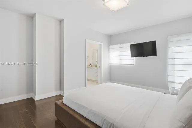 a large bed sitting in a bedroom next to a window