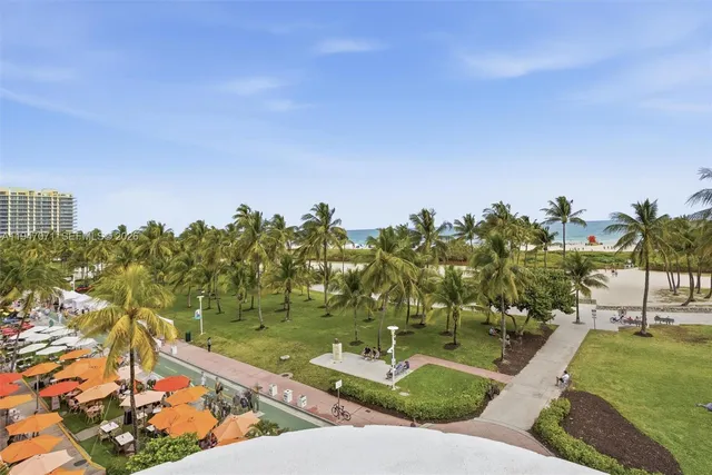 a kitchen with stainless steel appliances granite countertop a stove a refrigerator a kitchen island with chairs and wooden floor