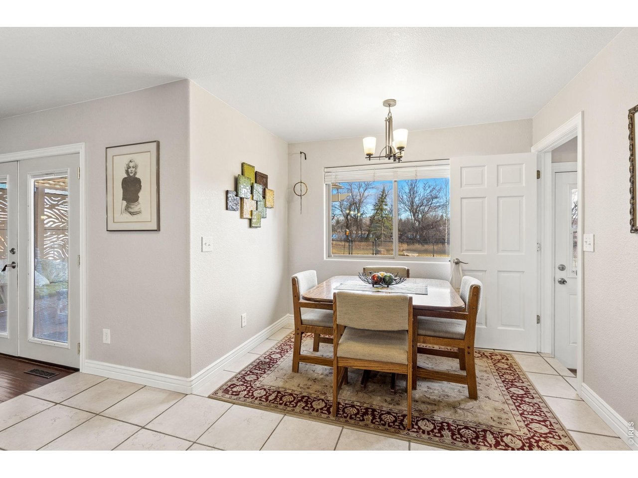 3000 Marion Street Fort Collins, CO 80521 - Photo 16 of 50 a dining room with wooden floor a chandelier a wooden table and chairs