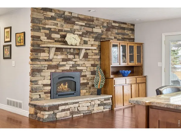 a kitchen with a wooden floor and a fireplace