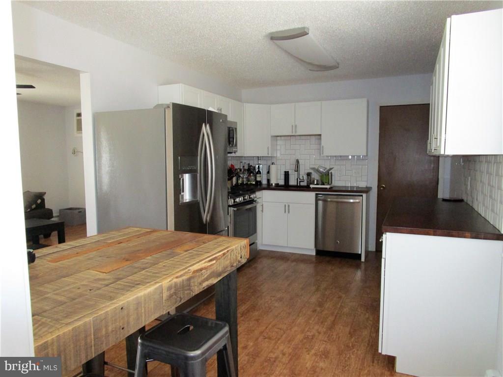 156 Dolphin Road Manahawkin, NJ 08050 - Photo 2 of 9 a kitchen with stainless steel appliances a refrigerator a sink a stove a table and chairs