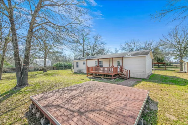 a view of a house with backyard and a tree
