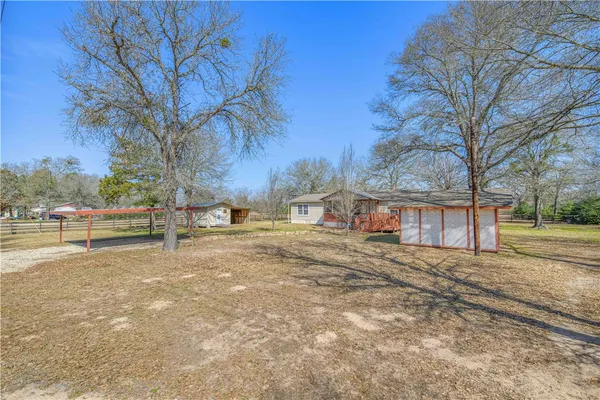 a view of a yard with wooden fence