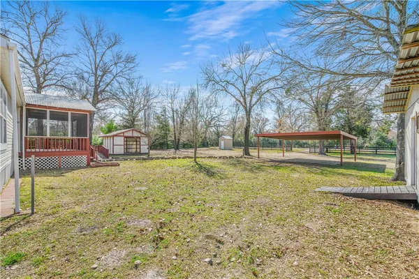 a view of a house with backyard and a tree