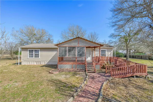 a view of a house with a wooden deck and a yard