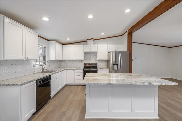 a large kitchen with a large counter top stainless steel appliances and cabinets