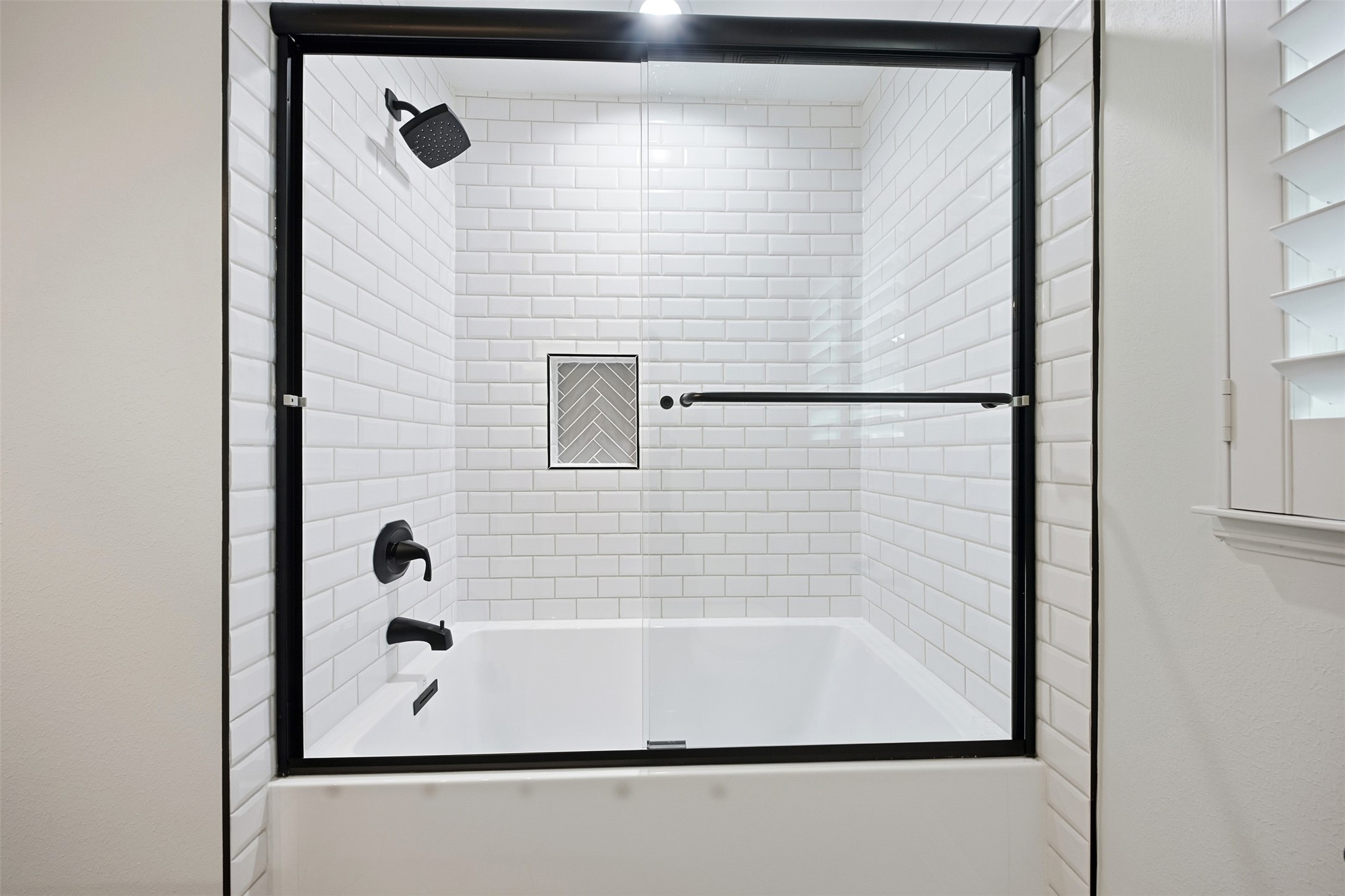 2015 Woodcrest Drive Houston, TX 77018 - Photo 19 of 30 This sleek glass-enclosed bathtub/shower combo features modern fixtures and elegant white subway tiles.