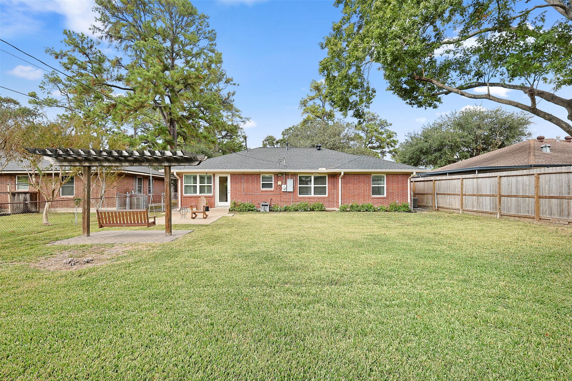 2015 Woodcrest Drive Houston, TX 77018 - Photo 21 of 30 Spacious backyard with well-maintained lawn, featuring a charming pergola with a swing.