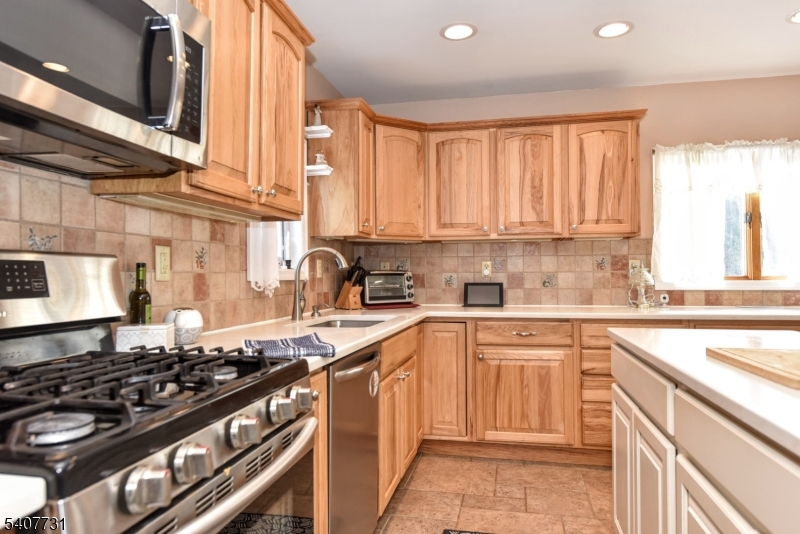 7 Birch Road Bloomingdale, NJ 07403 - Photo 12 of 45 a kitchen with a stove a sink and a refrigerator
