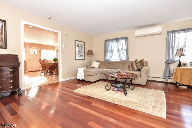 7 Birch Road Bloomingdale, NJ 07403 - Photo 17 of 45 a living room with furniture and a dining table with wooden floor