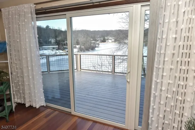 a view of a porch with furniture and floor to ceiling window