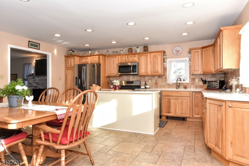 7 Birch Road Bloomingdale, NJ 07403 - Photo 8 of 45 a kitchen with stainless steel appliances kitchen island granite countertop a stove a sink a dining table and chairs
