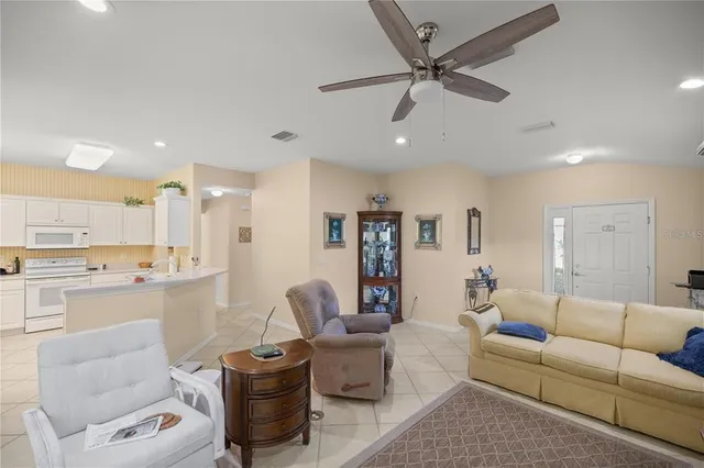a living room with furniture and a view of kitchen