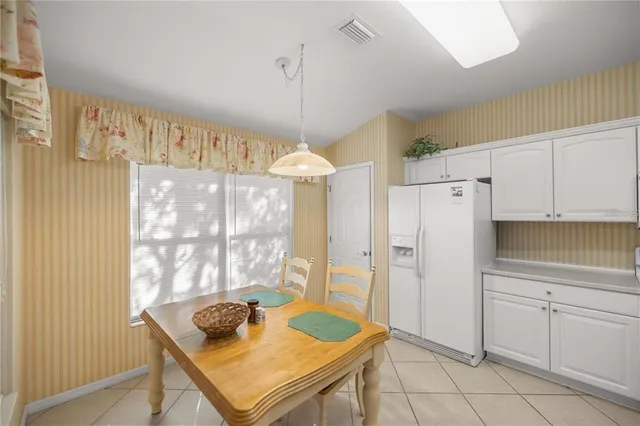 a kitchen with white cabinets and window