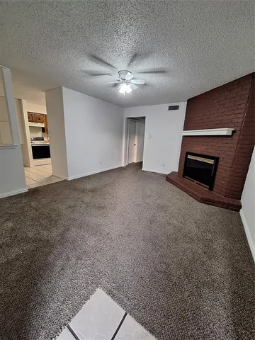 a view of an empty room with a fireplace and a window