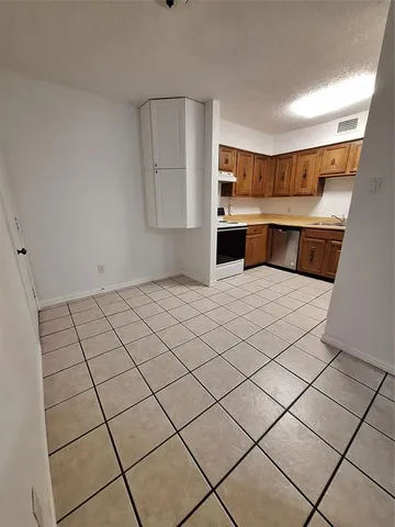 a kitchen with stainless steel appliances cabinets and wooden floor
