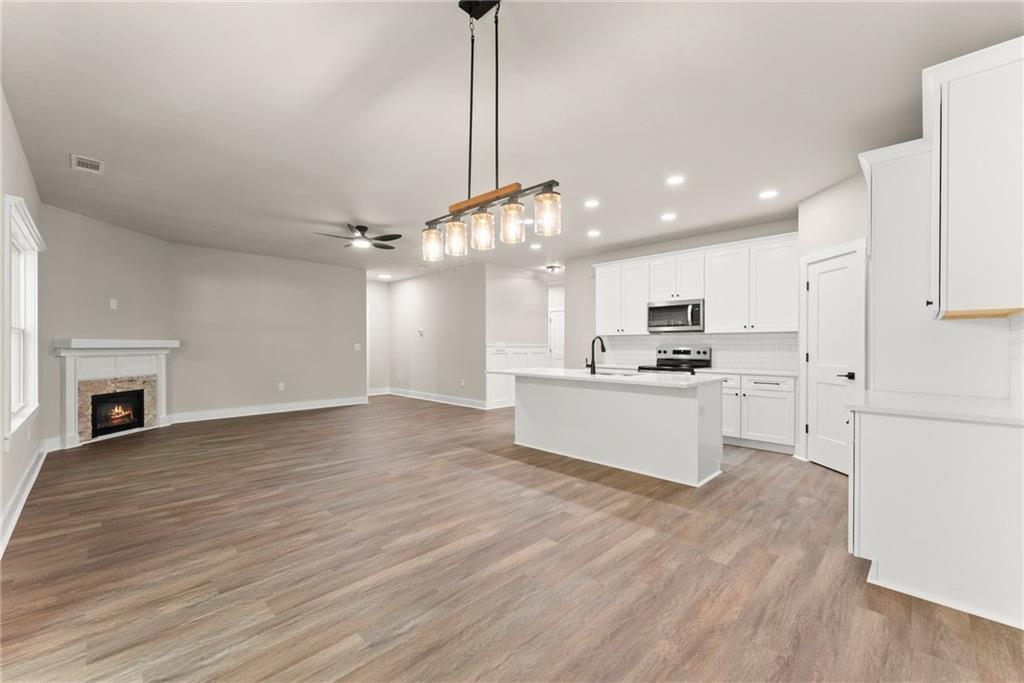 43 Anderson Street Jefferson, GA 30549 - Photo 12 of 45 a large kitchen with granite countertop a large counter top a sink stainless steel appliances and cabinets