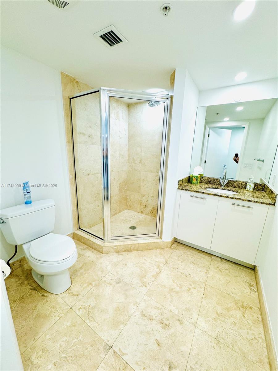 41 Southeast 5th Street, Unit 808 Miami, FL 33131 - Photo 11 of 39 a bathroom with a tub a toilet and a shower