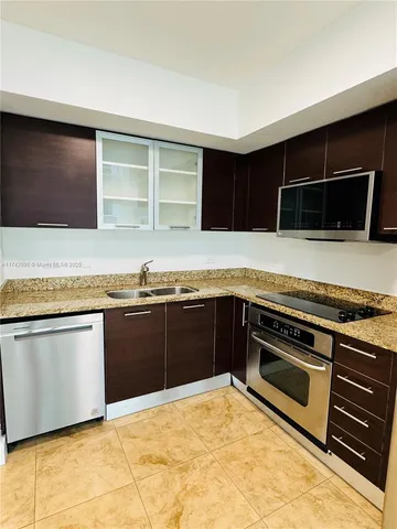 a kitchen with granite countertop a stove and a microwave
