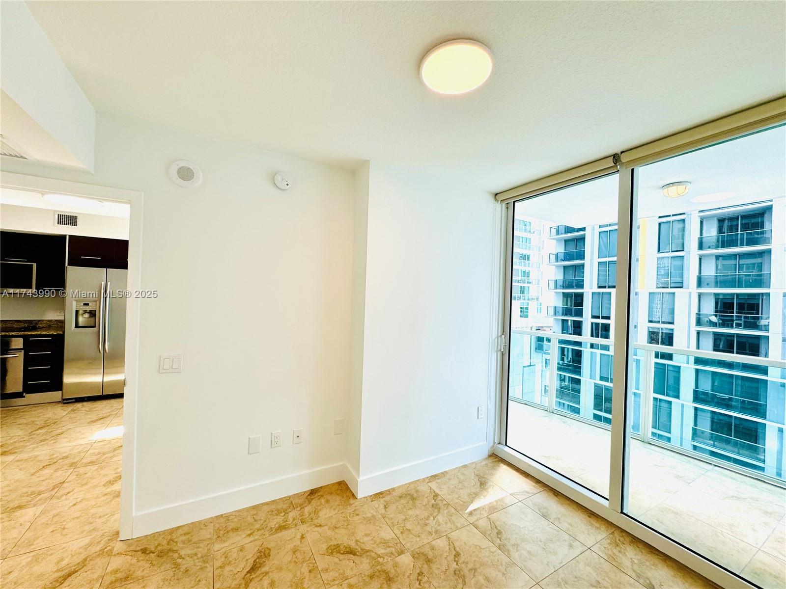 41 Southeast 5th Street, Unit 808 Miami, FL 33131 - Photo 4 of 39 a view of an empty room with window and kitchen view