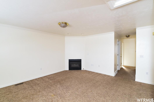 1130 North 200 West Bountiful, UT 84010 - Photo 4 of 11 Carpeted empty room with crown molding and a fireplace