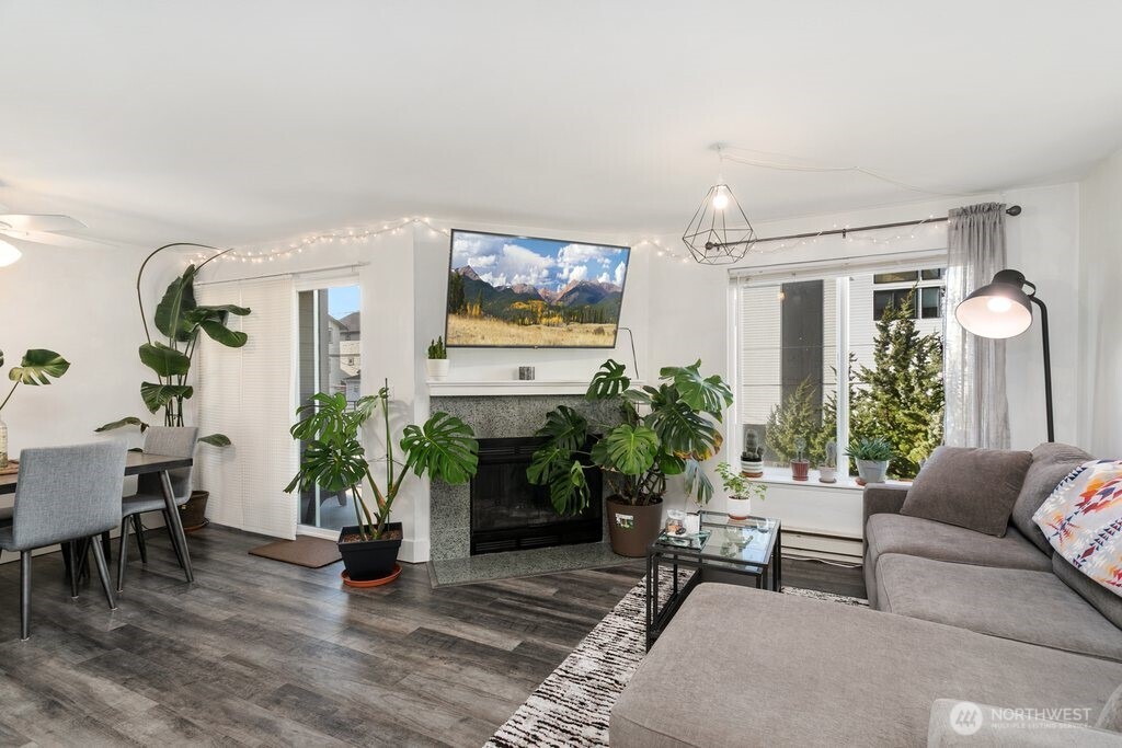 4831 Fauntleroy Way Southwest, Unit 206 Seattle, WA 98116 - Photo 1 of 21 a living room with furniture potted plant and a window
