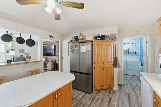 a kitchen with stainless steel appliances granite countertop a refrigerator a sink and wooden floors