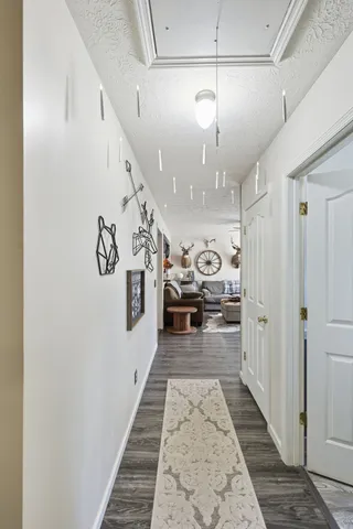 a view of a hallway with stairs and a chandelier