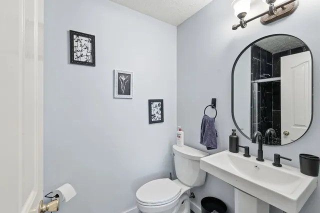 a bathroom with a toilet sink and mirror