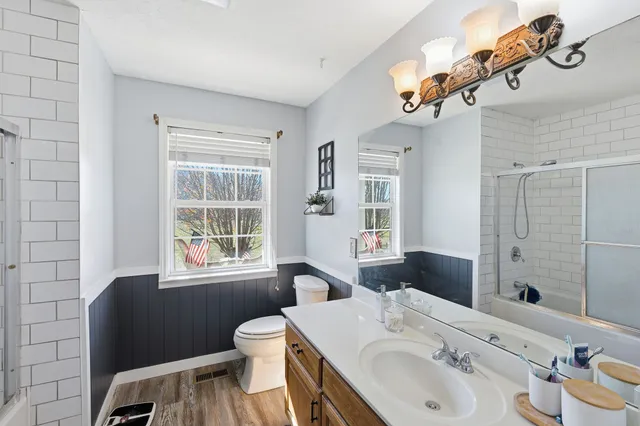 a bathroom with a sink a toilet and a mirror