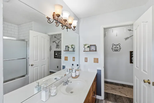 a bathroom with a double vanity sink mirror and shower