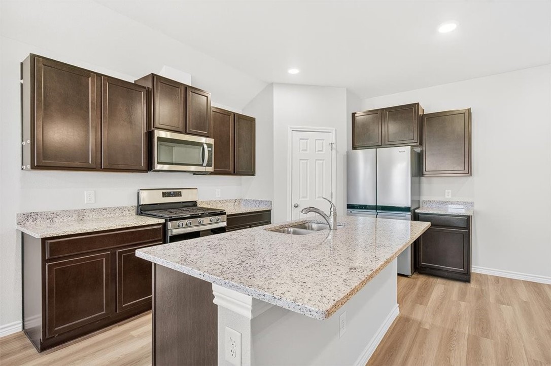 1626 Comfy Way Corpus Christi, TX 78418 - Photo 11 of 40 a kitchen with granite countertop stainless steel appliances a sink stove and refrigerator