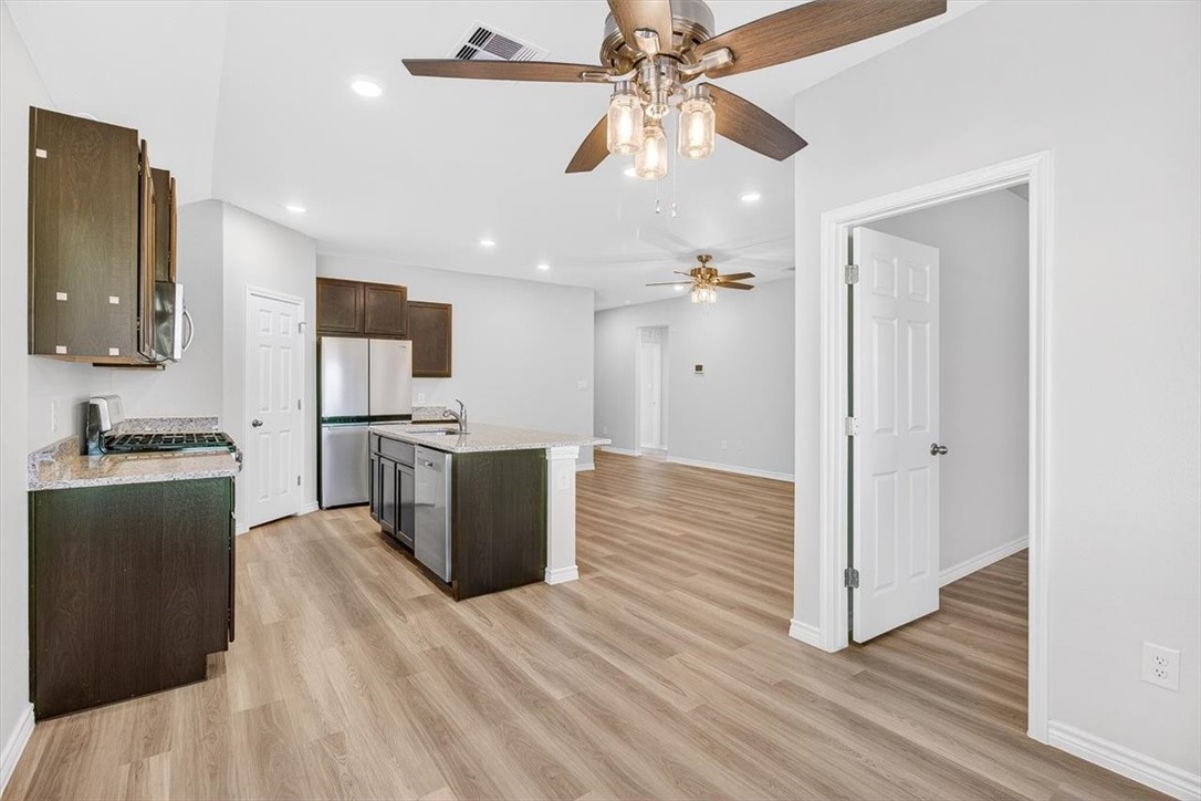 1626 Comfy Way Corpus Christi, TX 78418 - Photo 15 of 40 a view of a kitchen with wooden floor and a ceiling fan