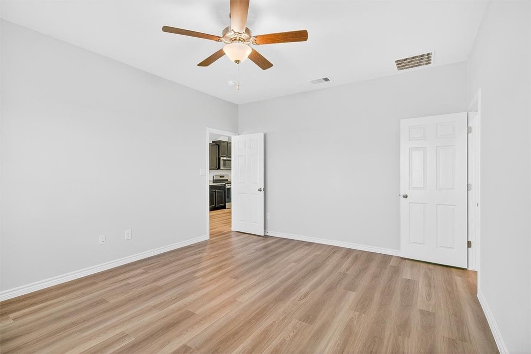 1626 Comfy Way Corpus Christi, TX 78418 - Photo 18 of 40 an empty room with wooden floor chandelier fan and closet area with wooden floor