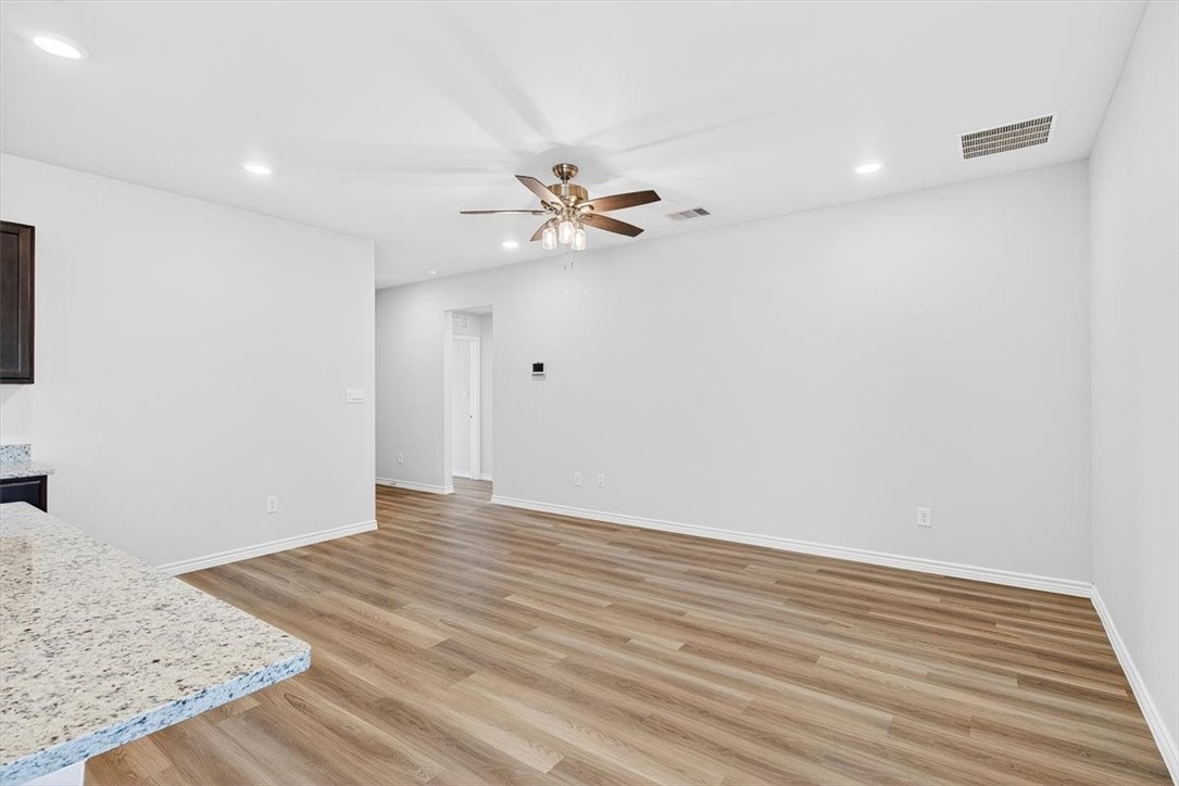 1626 Comfy Way Corpus Christi, TX 78418 - Photo 5 of 40 a view of a room with wooden floor and a ceiling fan