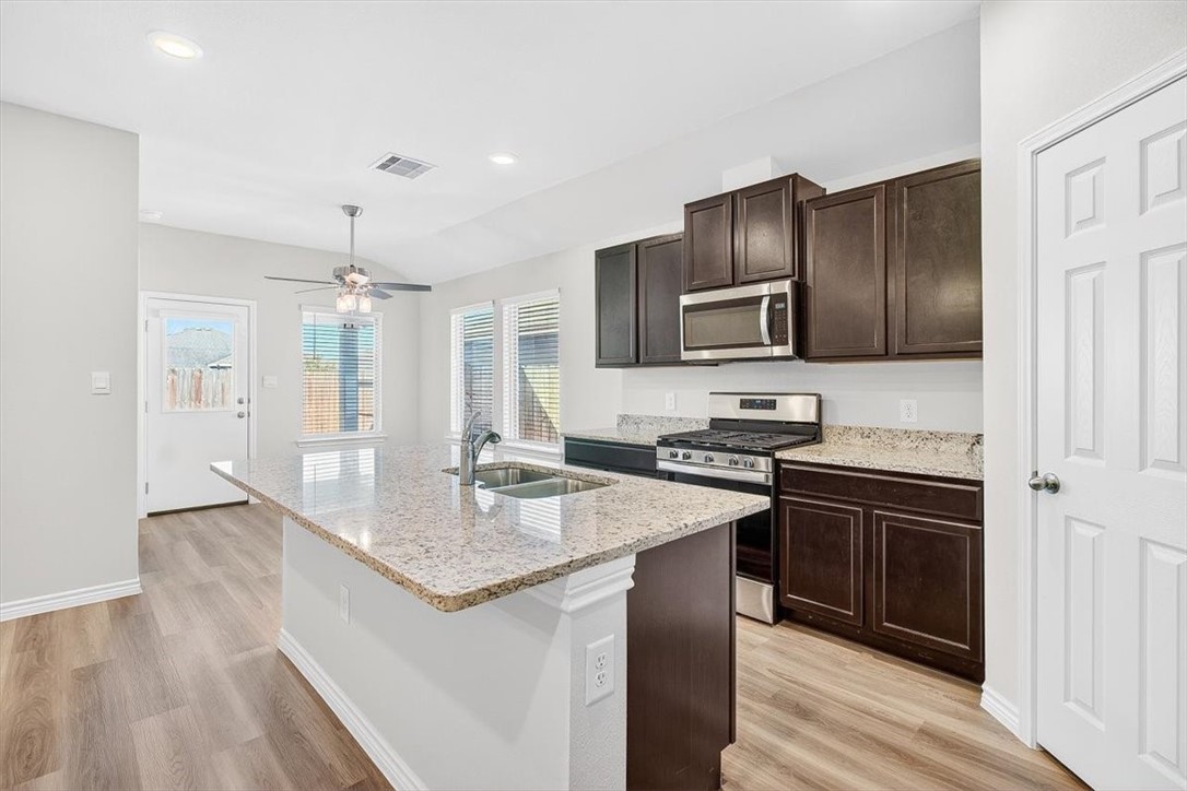 1626 Comfy Way Corpus Christi, TX 78418 - Photo 7 of 40 a kitchen with stainless steel appliances granite countertop a sink stove and refrigerator