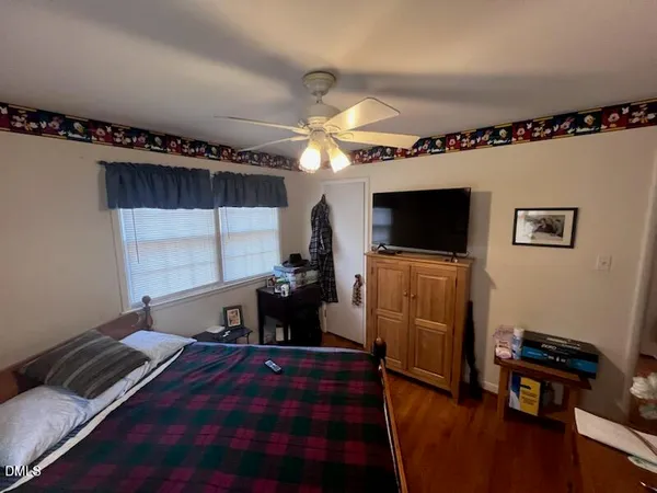 a bedroom with bed and flat tv screen