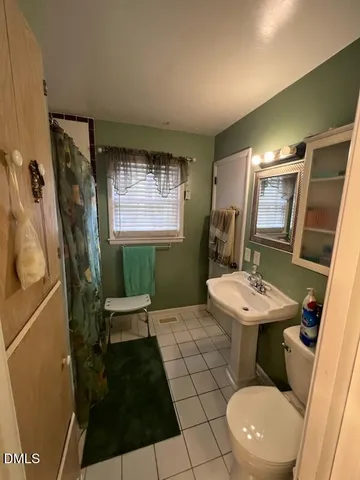 a bathroom with a sink toilet and mirror