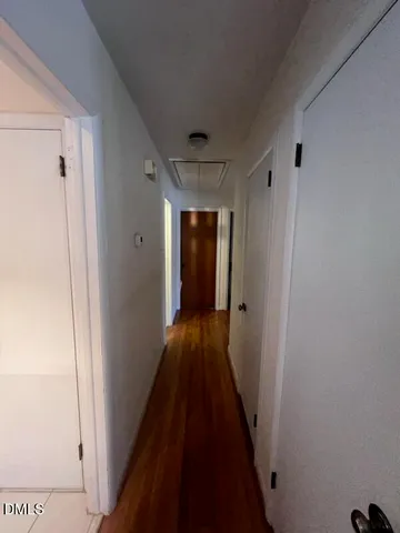 a view of a hallway with wooden floor and closet