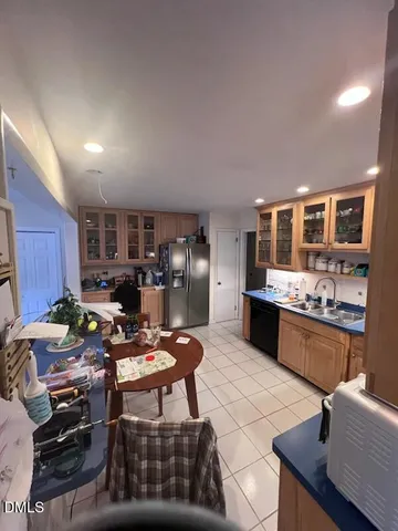 a kitchen with stainless steel appliances kitchen island granite countertop a stove refrigerator and cabinets