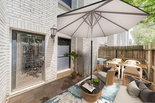 a patio with table and chairs under an umbrella