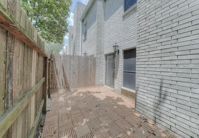 a view of backyard with large trees and wooden fence