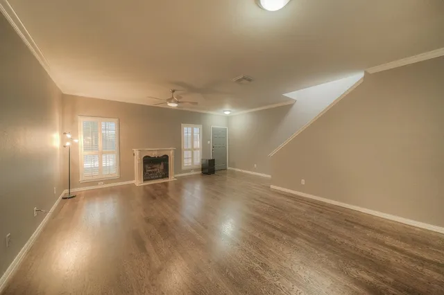an empty room with wooden floor and fireplace