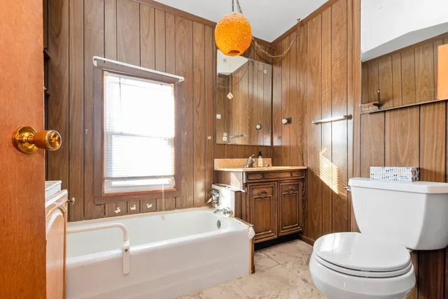 a bathroom with a bathtub toilet mirror and vanity