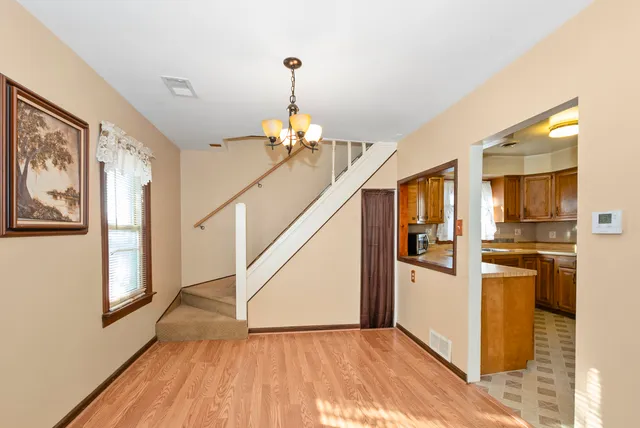 a view of a hallway with wooden floor windows and a kitchen