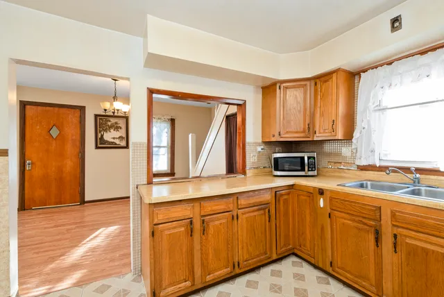 a kitchen with stainless steel appliances granite countertop a refrigerator a stove and white cabinets with wooden floor